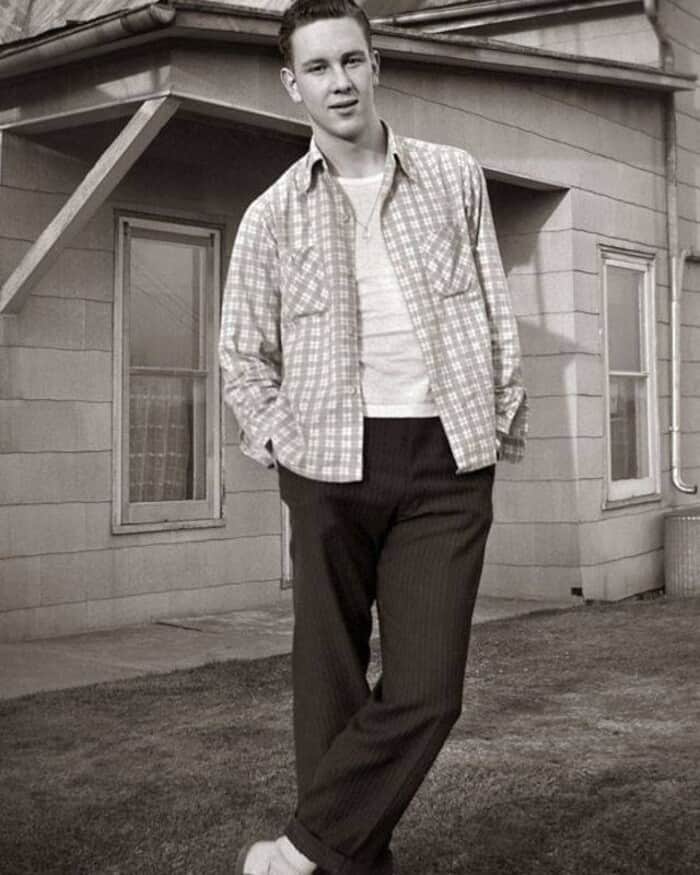 man in 1950s wearing an unbuttoned checked shirt