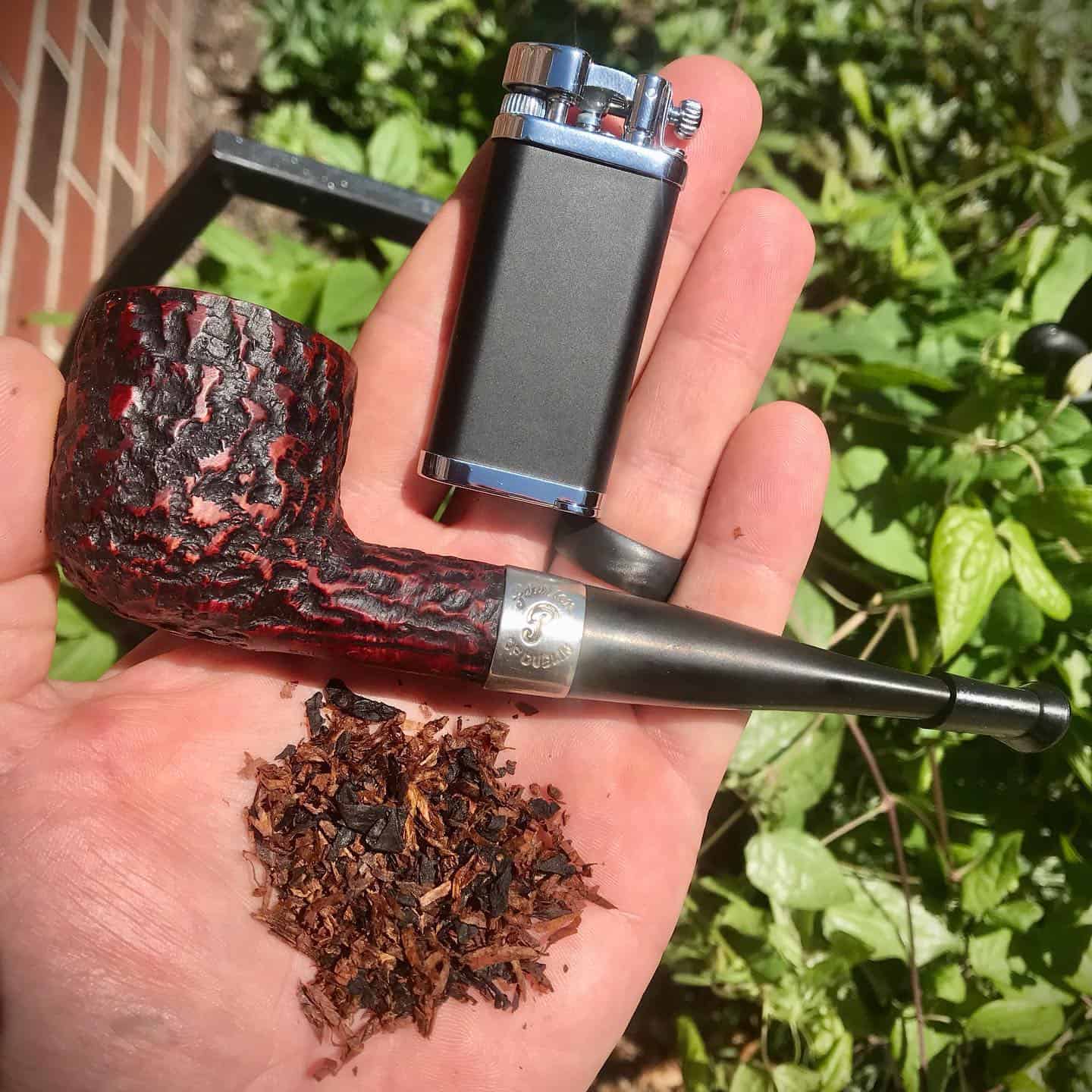 tobacco, pipe and lighter on hand