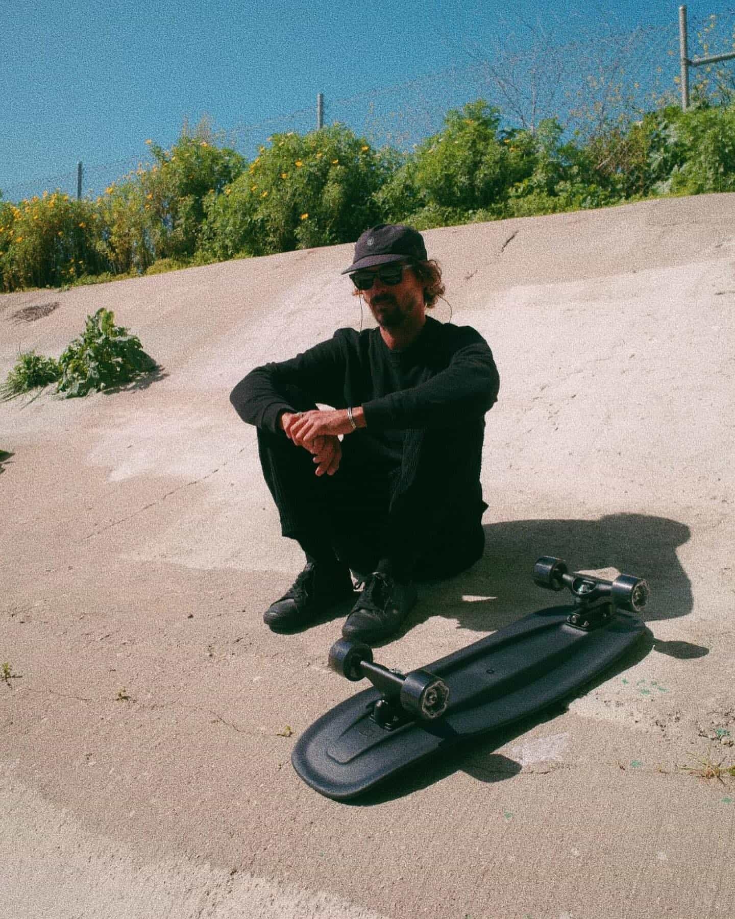 man in a black outfit sitting on the ground