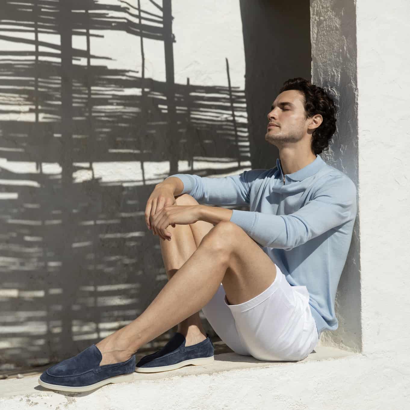 man in a buttonless polo shirt and white shorts