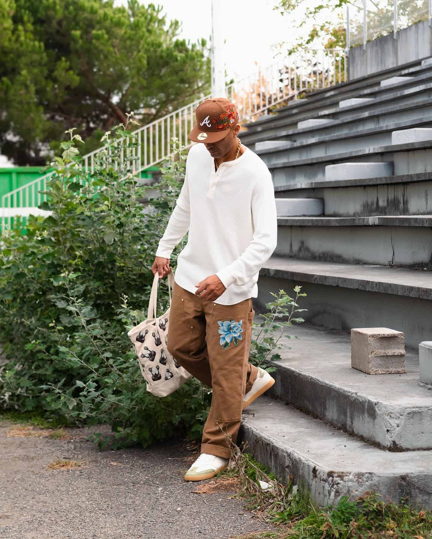 man wearing a brown hat carrying a tote bag