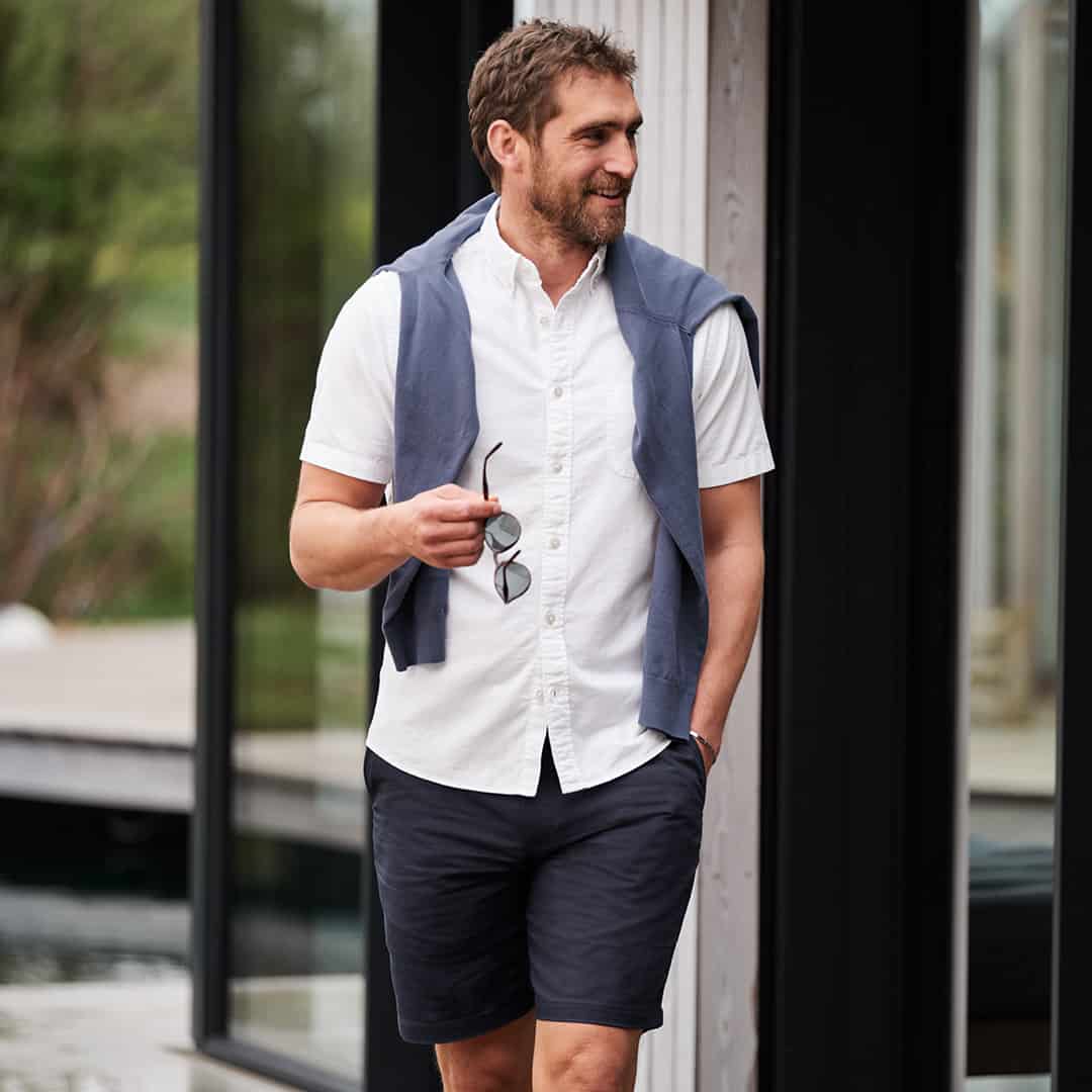 man wearing a white button down shirt and linen shorts