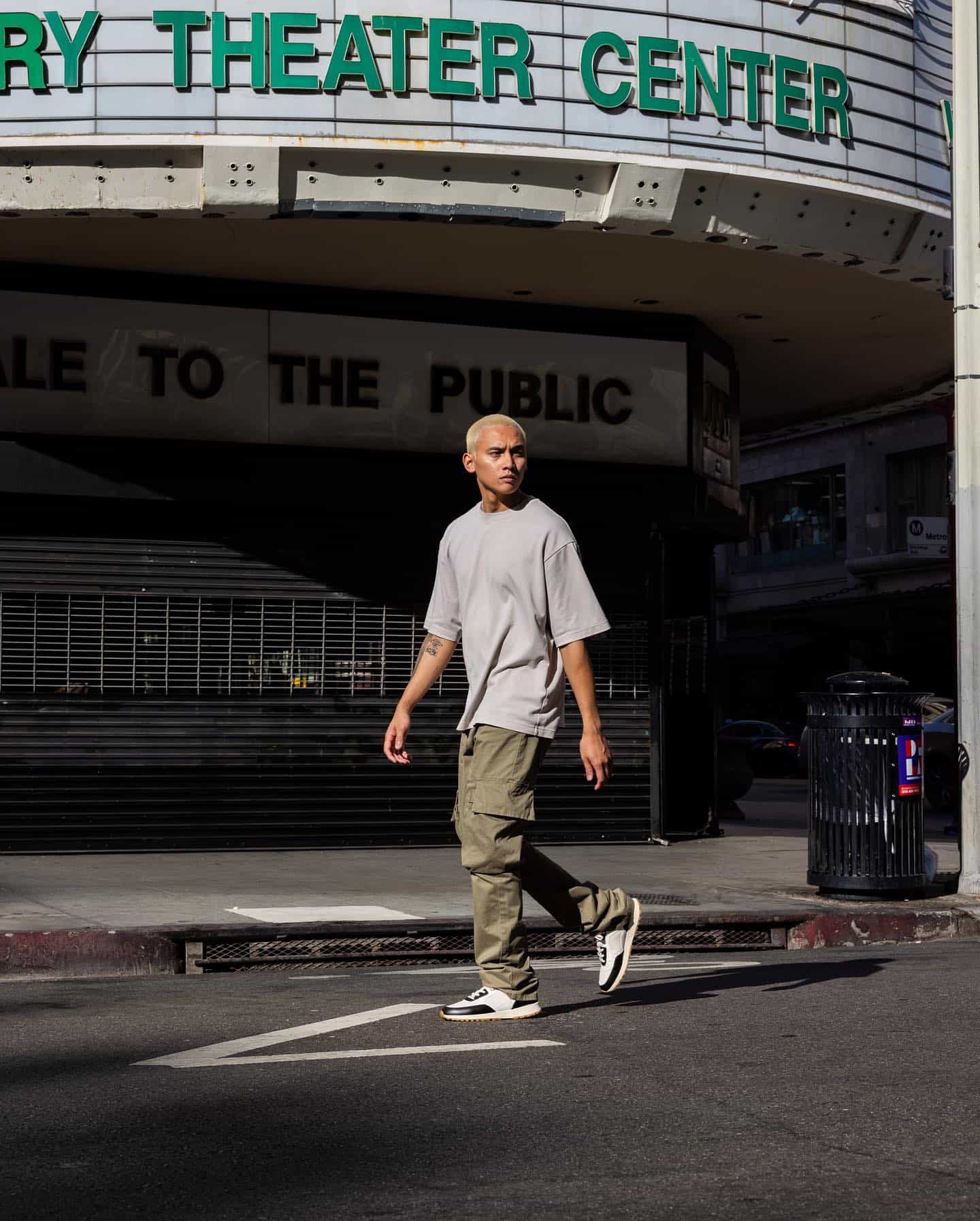 streetwear aesthetic: man in a gray shirt and green cargo pants walking the streets