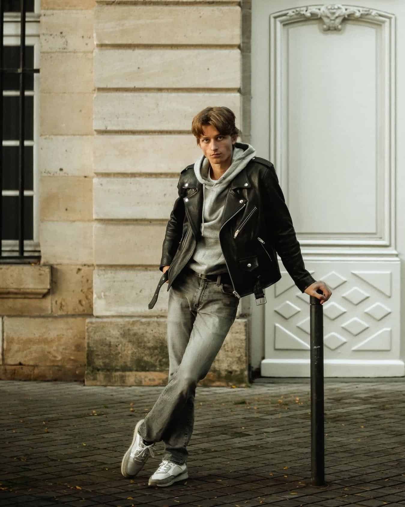 man in a hoodie layered with a leather jacket