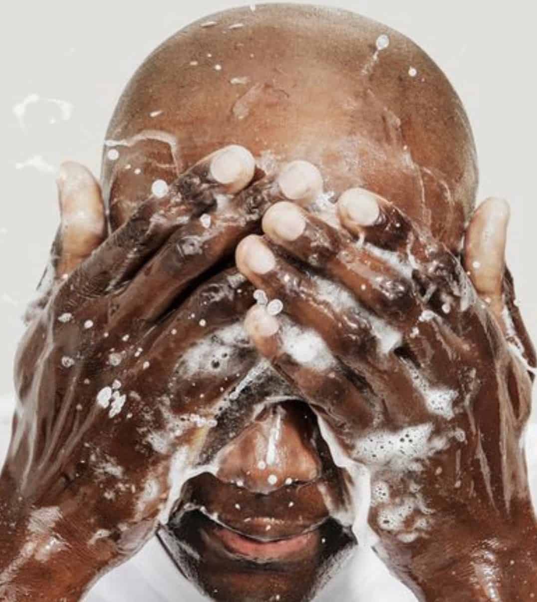 man rinsing the soap off of his face