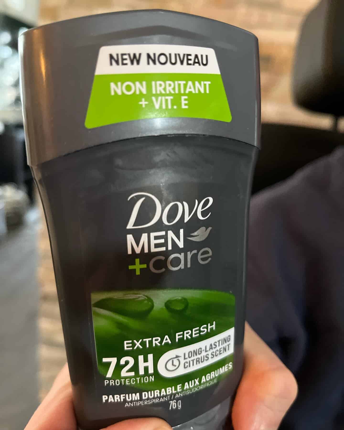 holding an extra fresh deodorant stick by dove men care