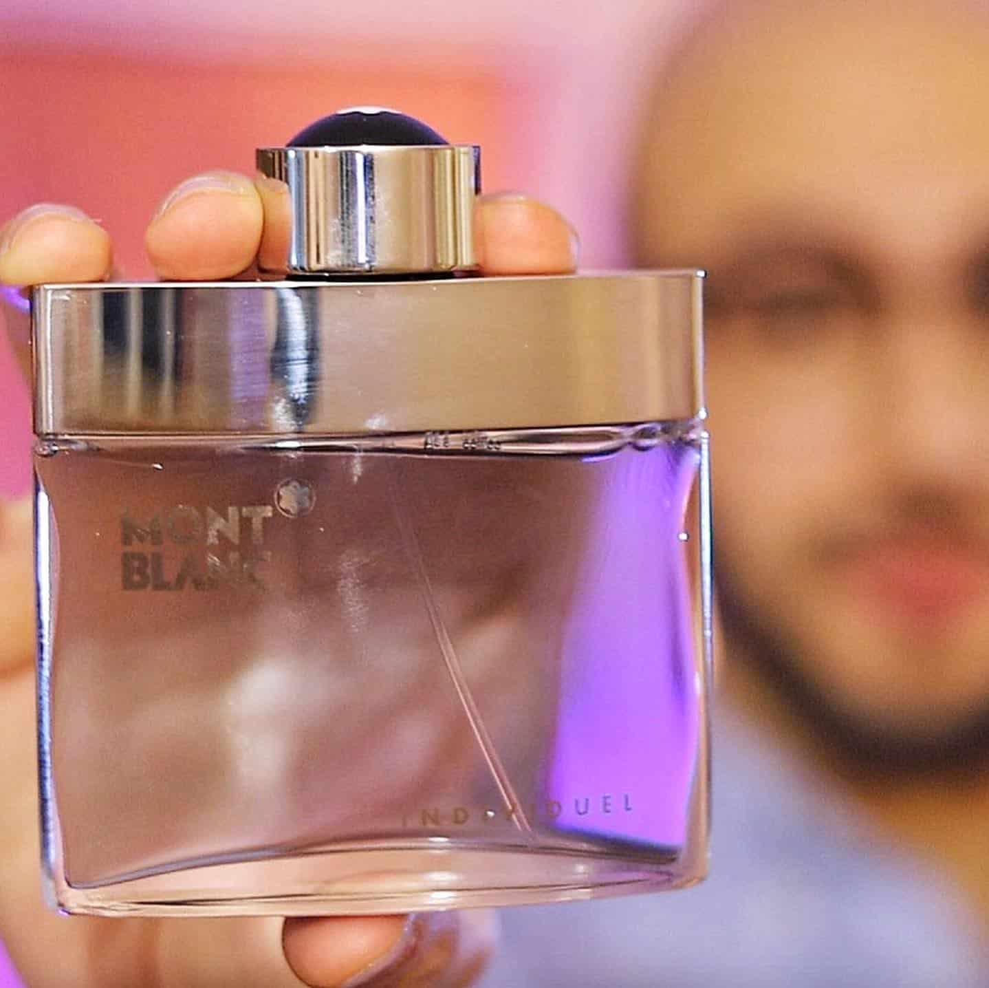 man holding a bottle of montblanc individuel cologne