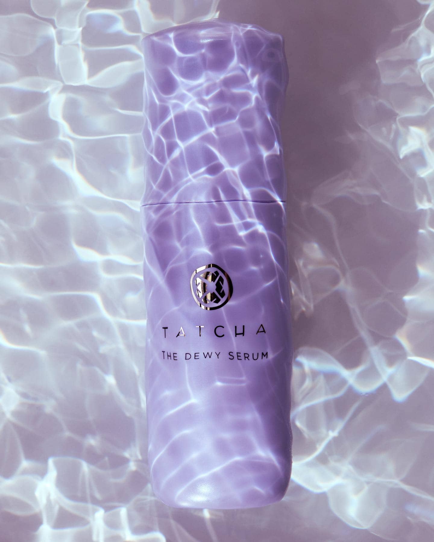 a bottle of the dewy serum by tatcha in the water