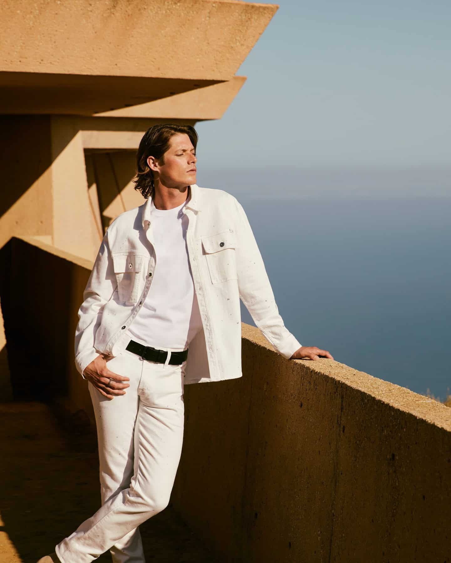 man wearing a white denim jacket and jeans