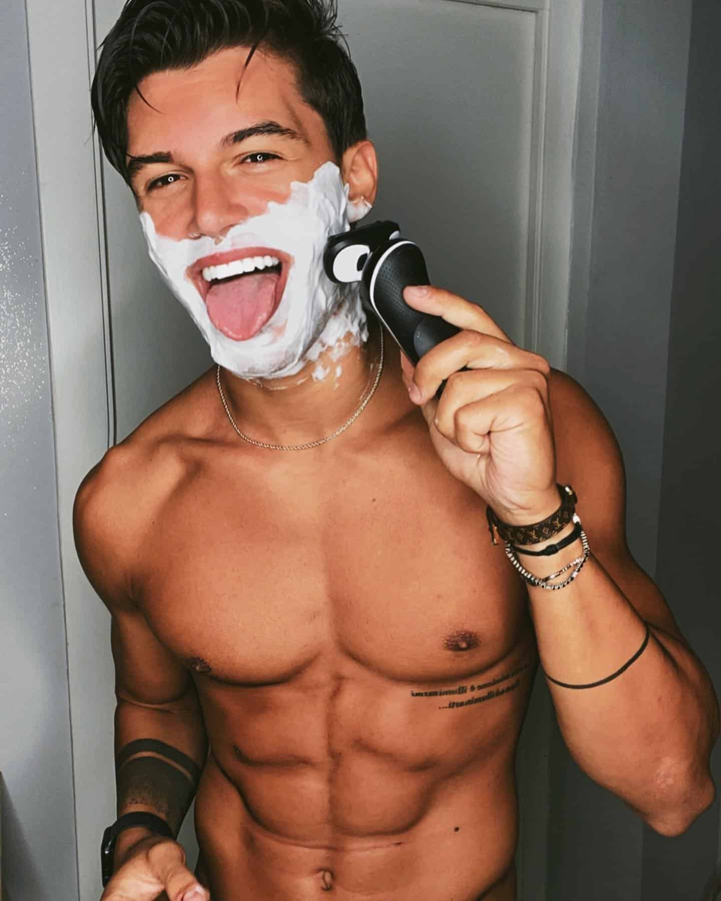 man sticking his tongue out while shaving