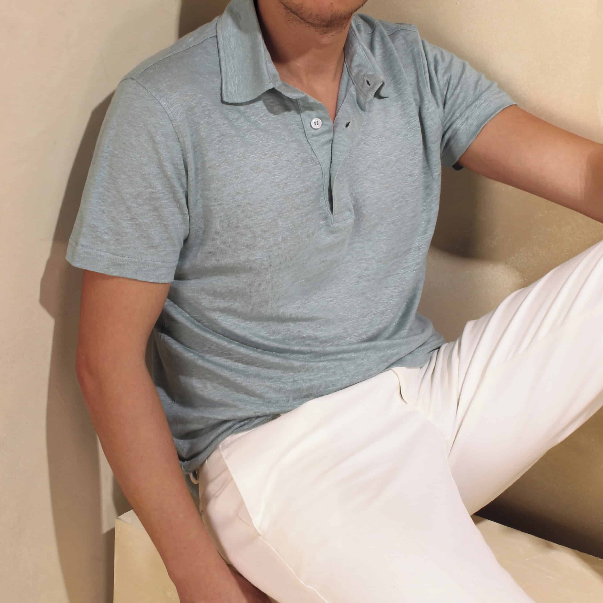 man wearing a gray shirt and white trousers