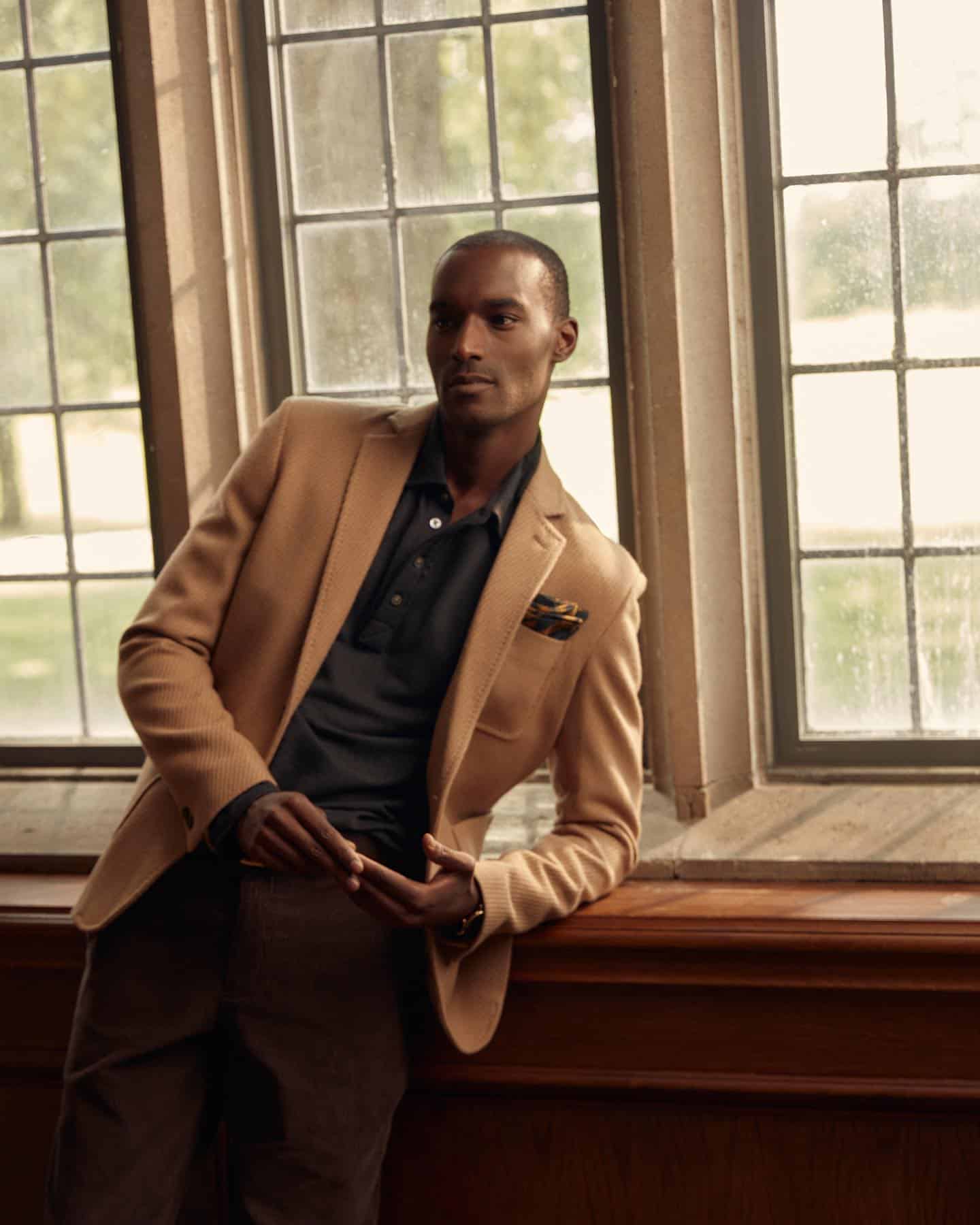 man by the window in a brown blazer