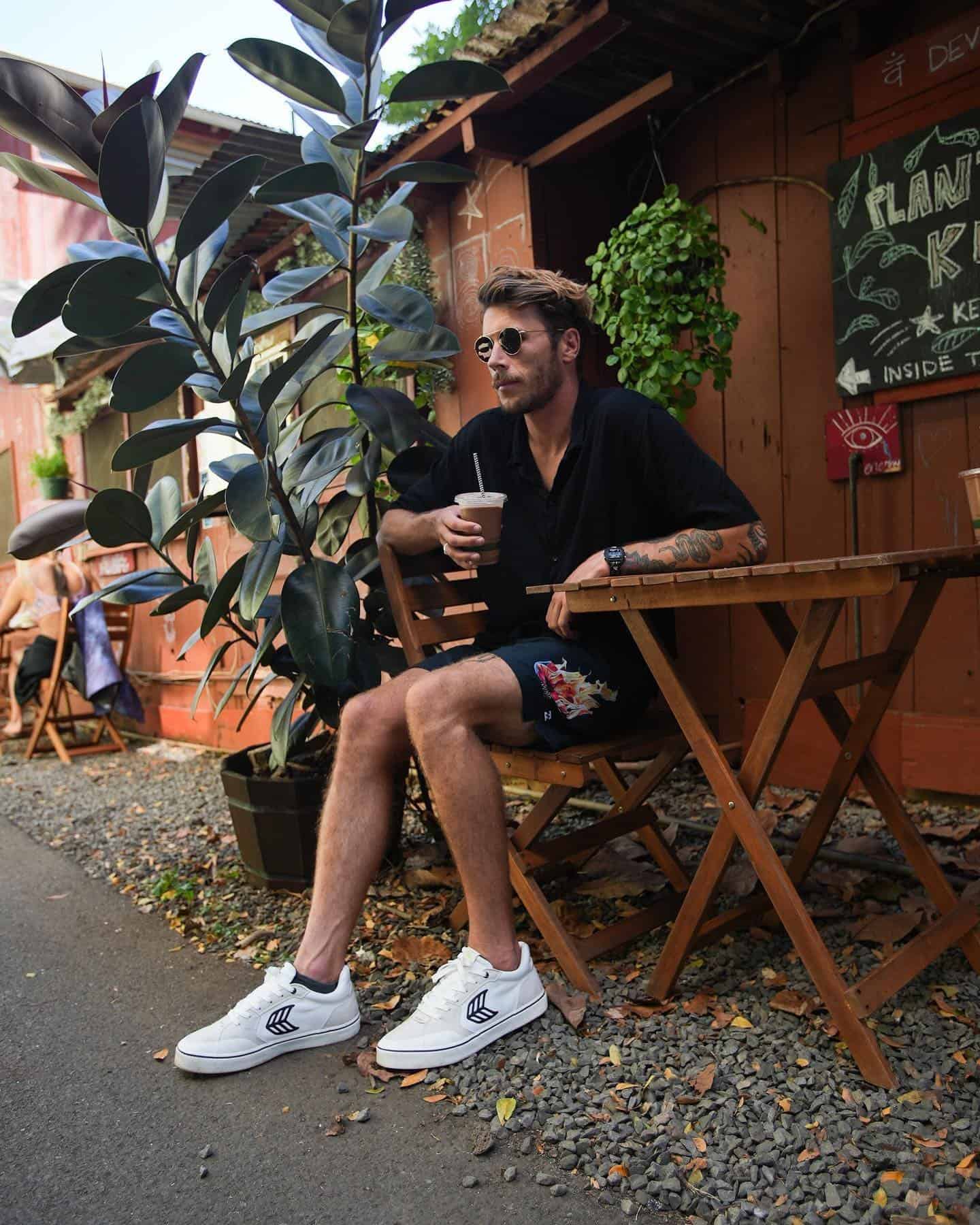 man having a cold drink outside a local cafe