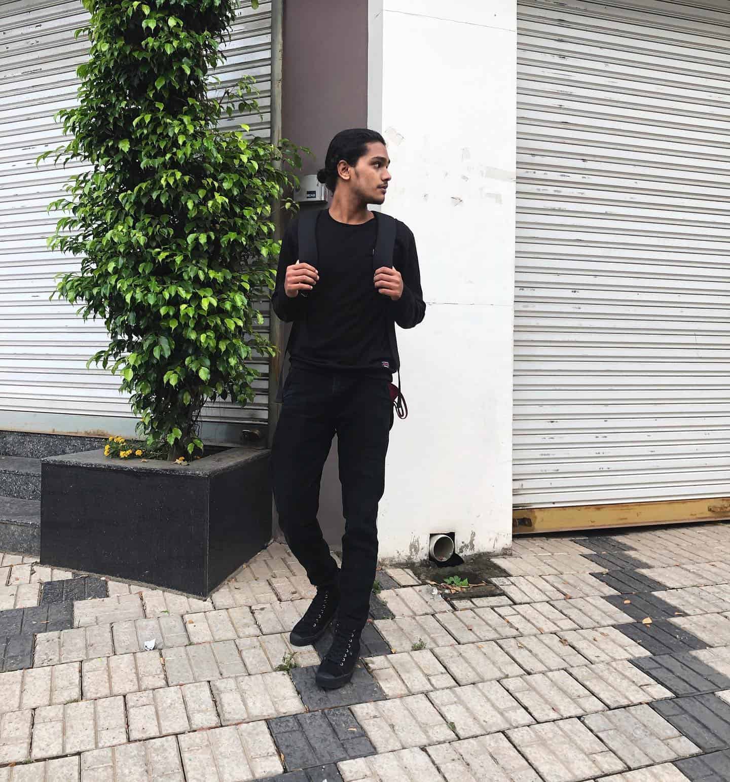 man with backpack wearing an all black outfit