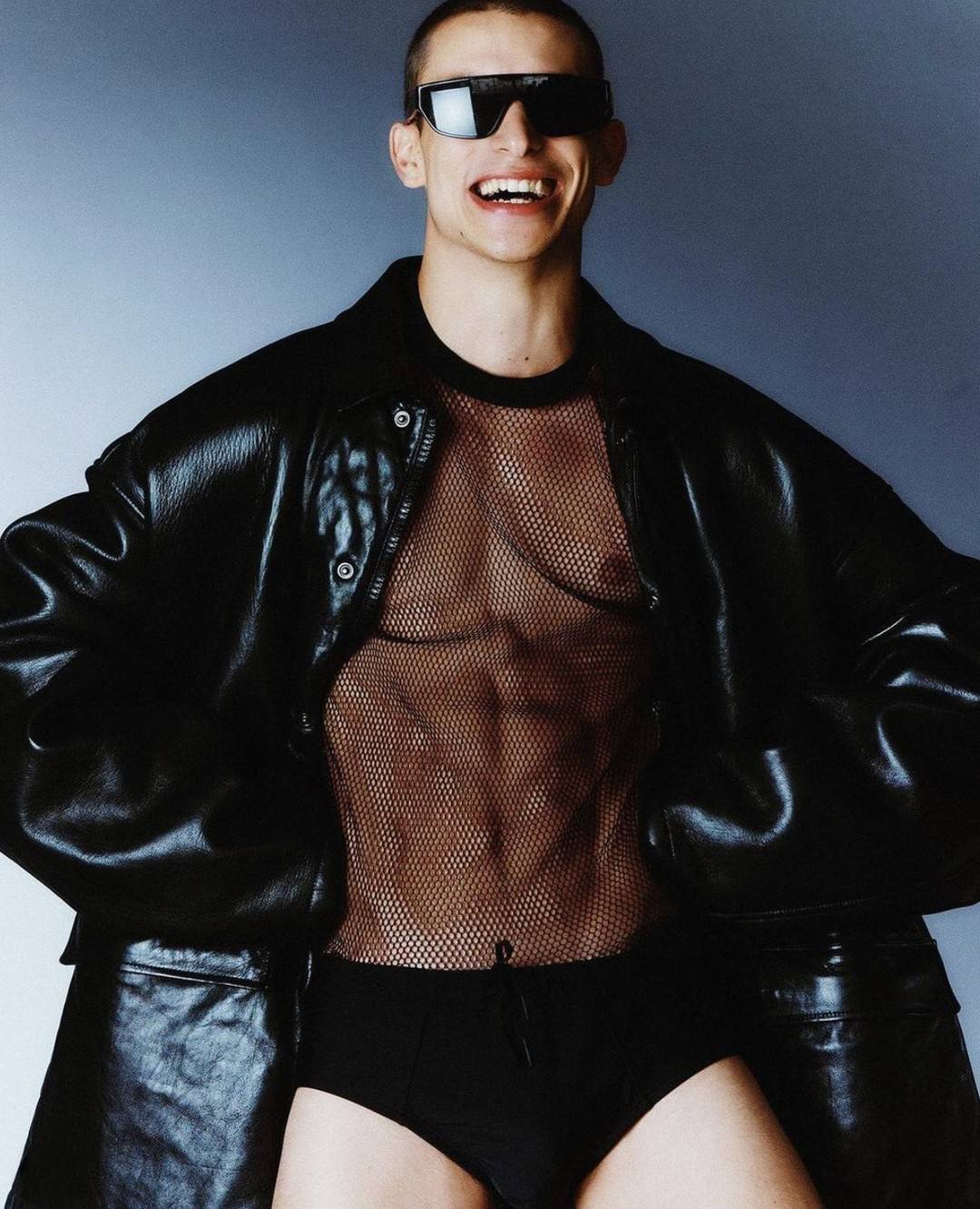 punk style: man with sunglasses wearing a mesh t-shirt and leather jacket