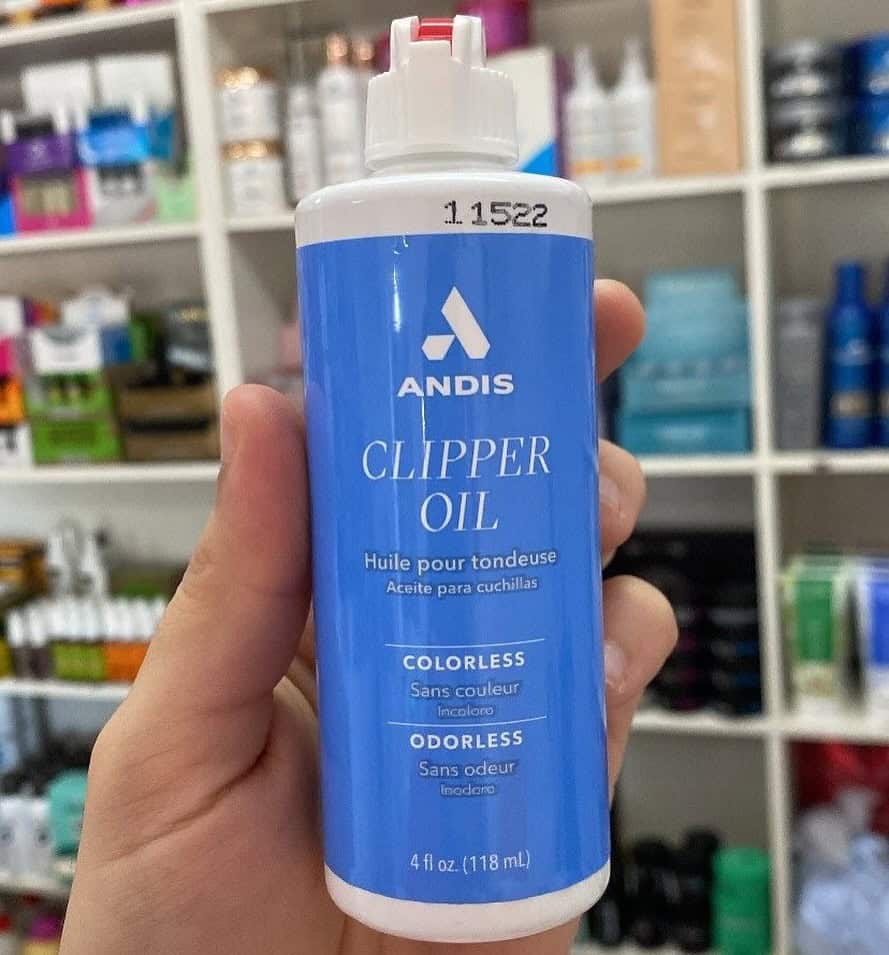 holding a bottle of andis clipper oil