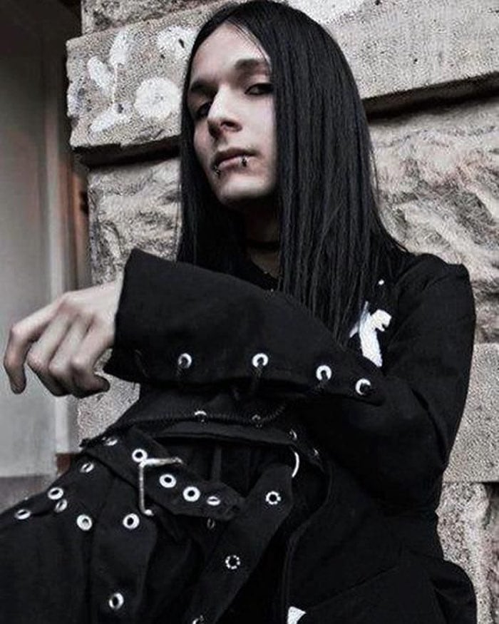 man with long hair wearing an all black outfit