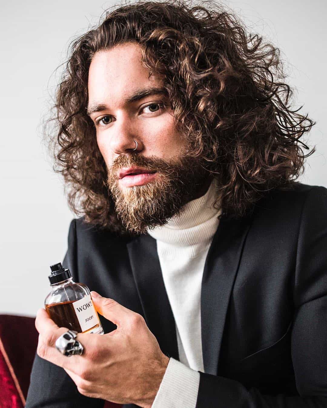 man holding a bottle of wow joop cologne