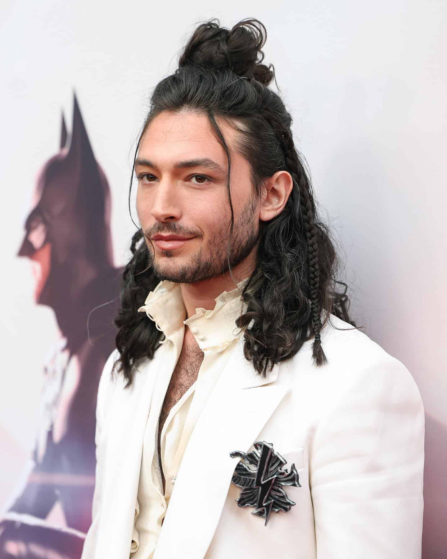 ezra miller with long hair and a man bun