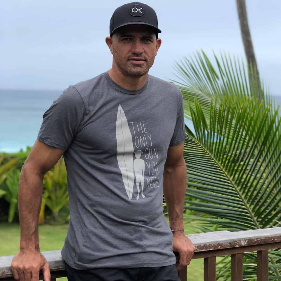 kelly slater in a black hat and grey shirt with print