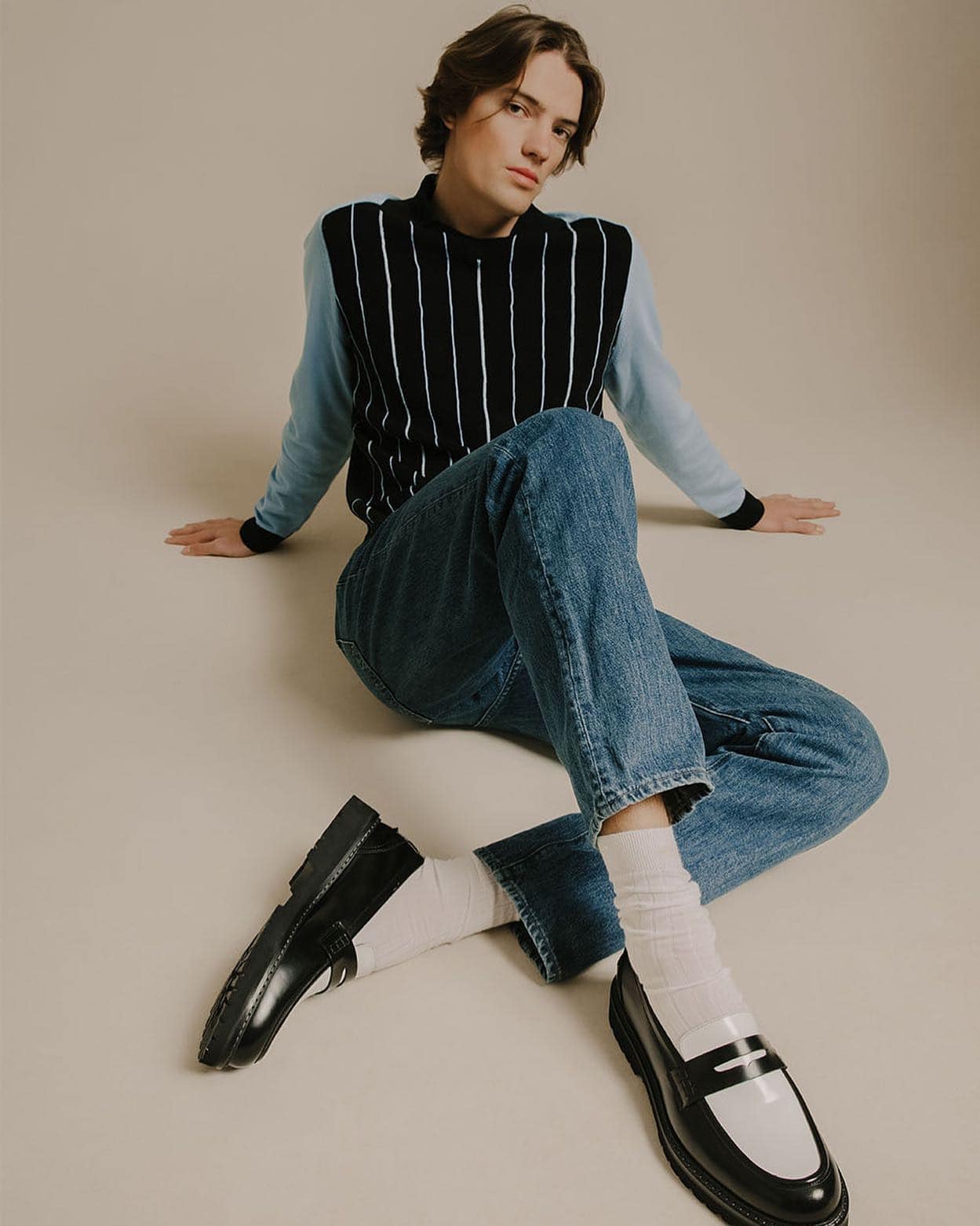 man sitting on the floor wearing a pair of arezzo dice loafers