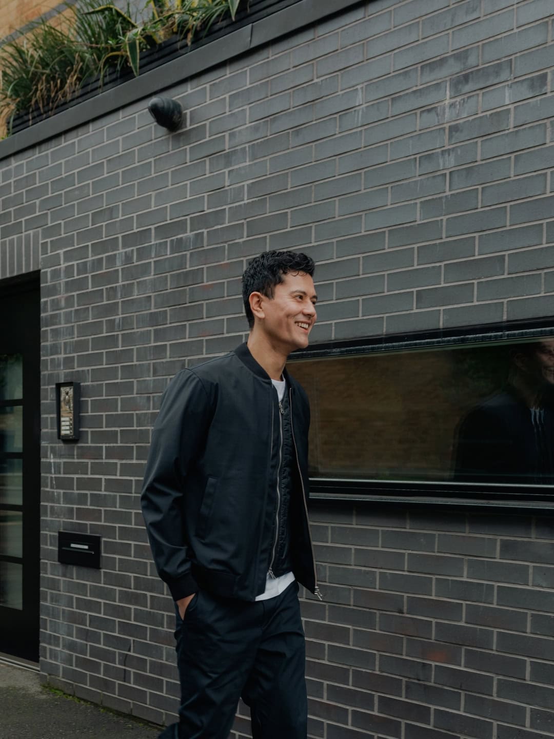 man wearing a bomber jacket over a vest