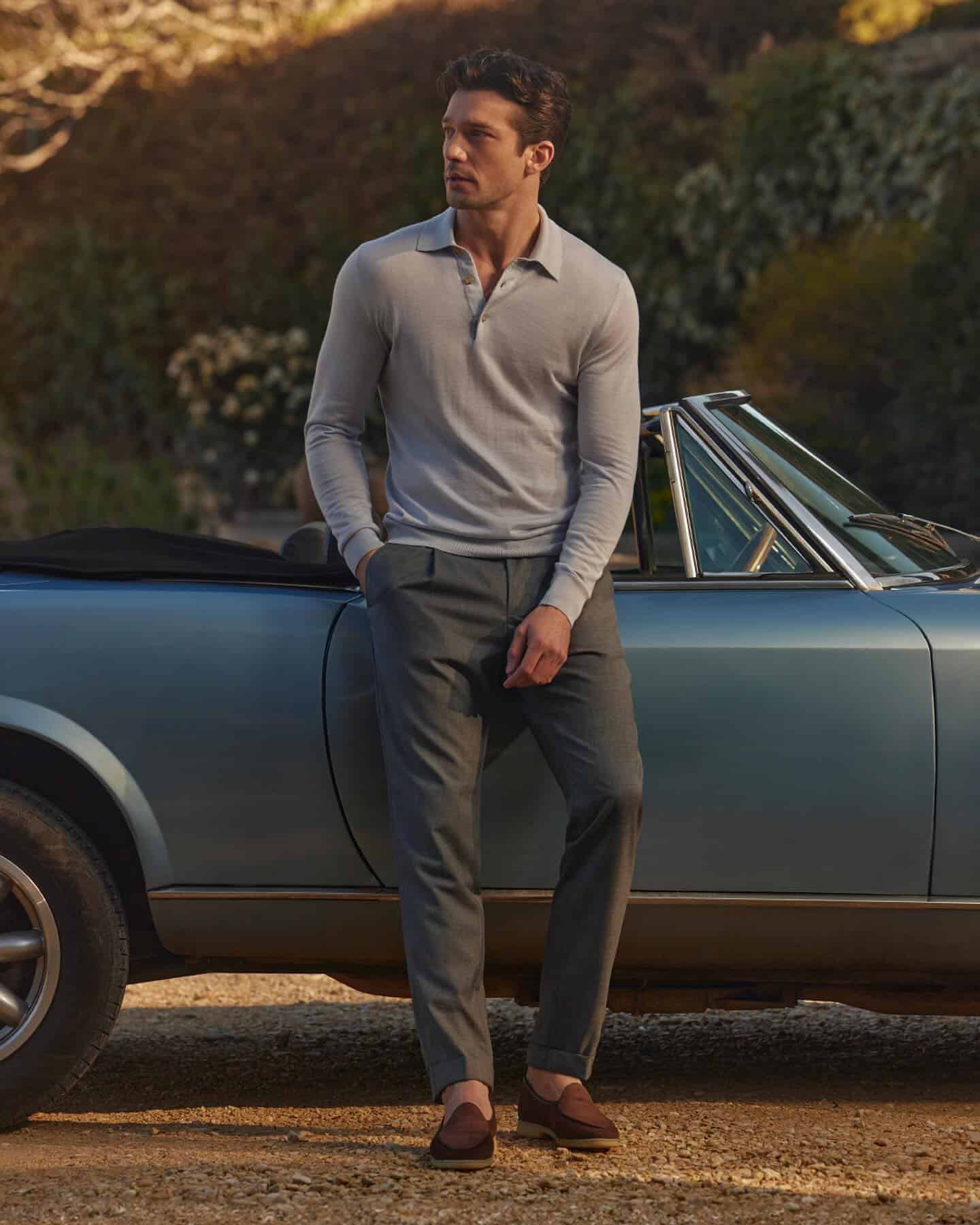 man standing beside a convertable