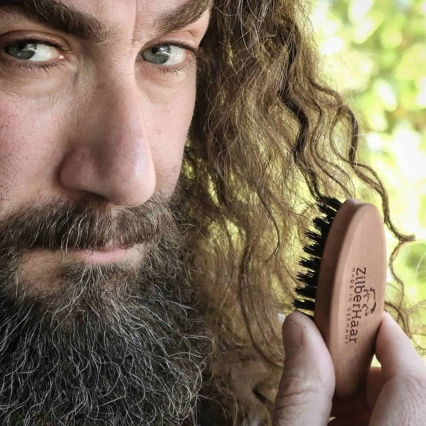 full bearded man holding the ZilberHaar pocket beard brush