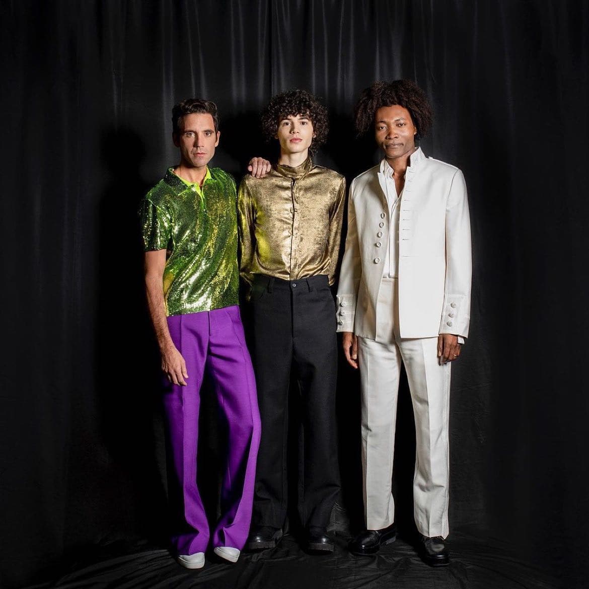 three men wearing colorful disco outfits