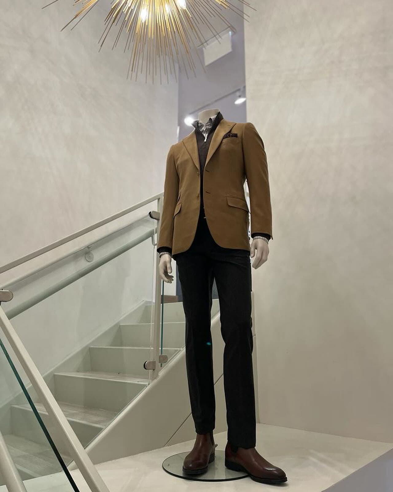 a headless mannequin wearing brown suit and black trousers