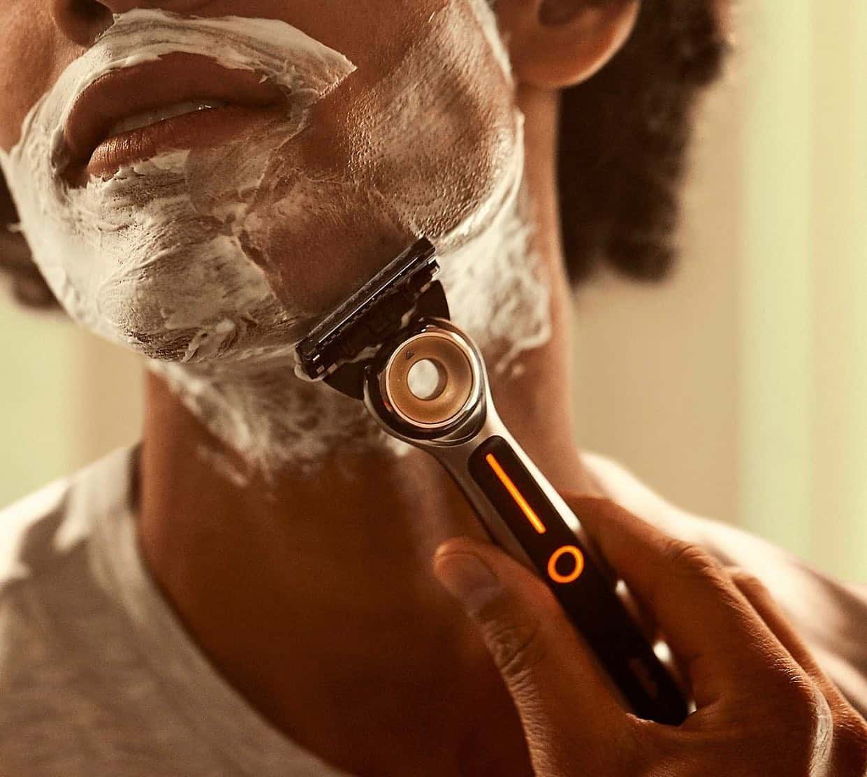 man using a heated razor to shave beard