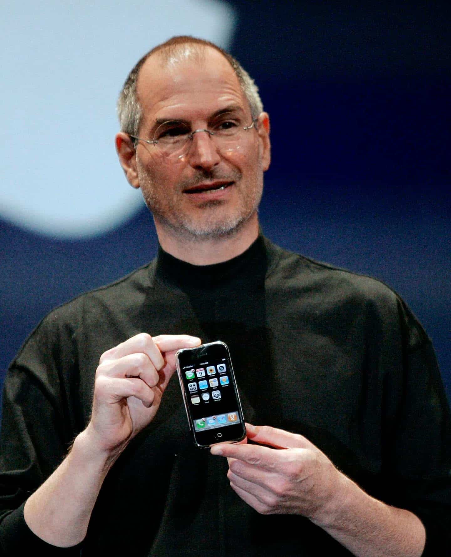 steve jobs in a black turtle neck holding the iphone 7