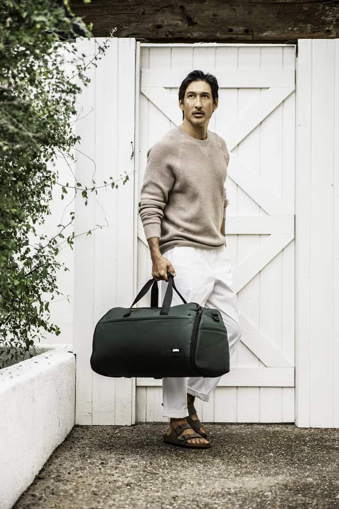 Man Carrying a Green Duffel bag by Halfday