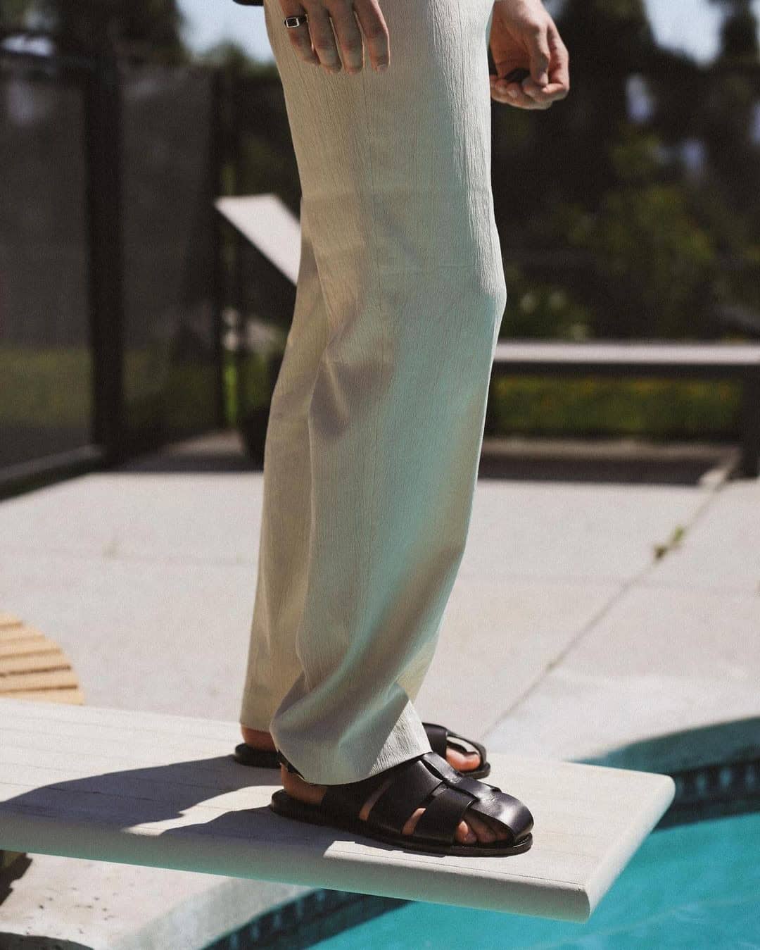 man standing on a diving board wearing a pair of allen edmonds monaco cross band sandal