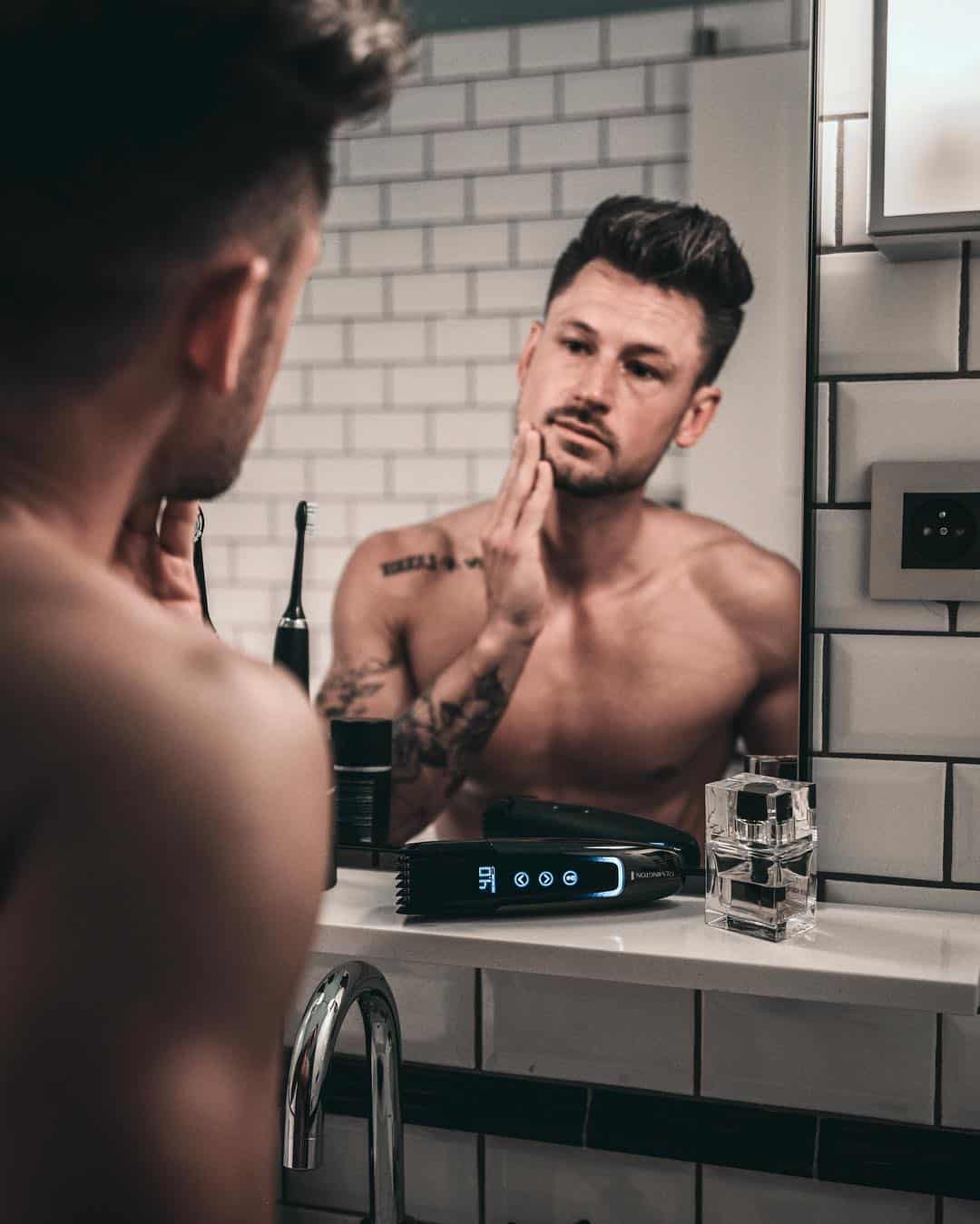 man checking his face on the mirror