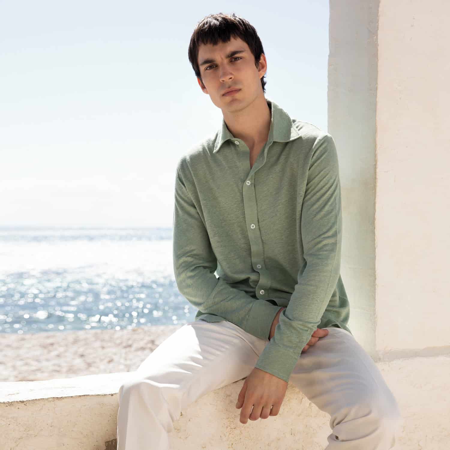 man at the beach wearing the Pistache Linen Bayside Shirt by Aurelien