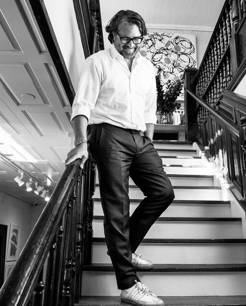 man going down the stairs wearing a shirt and pants