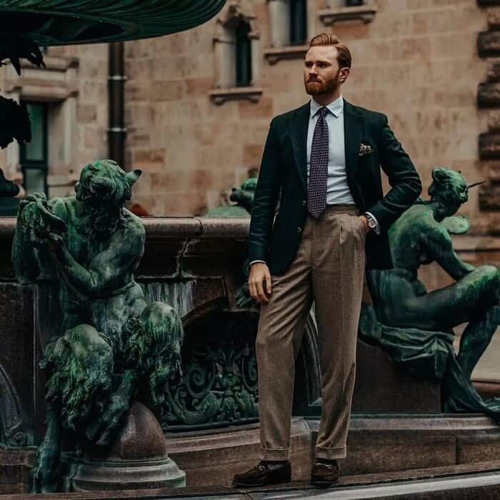 man standing by the fountain wearing a green blazer