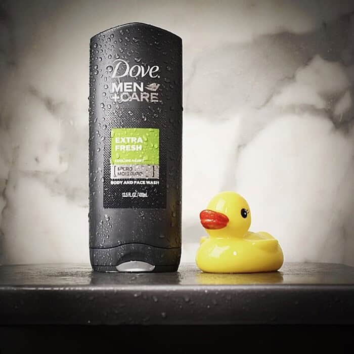 a bottle of dove men care extra wash body and face wash beside a rubber duck