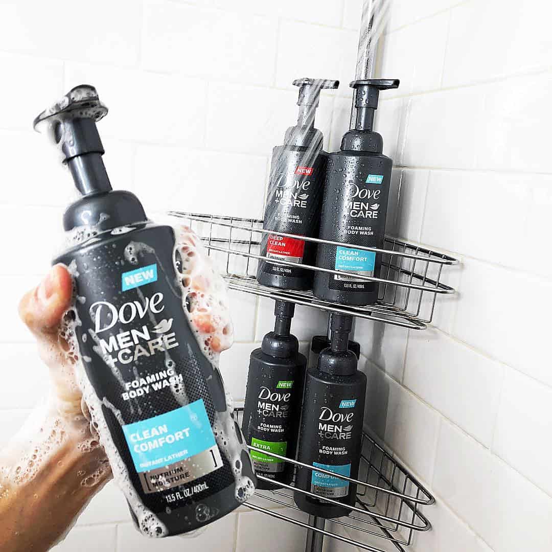 holding a bottle of dove men care clean comfort foaming body wash