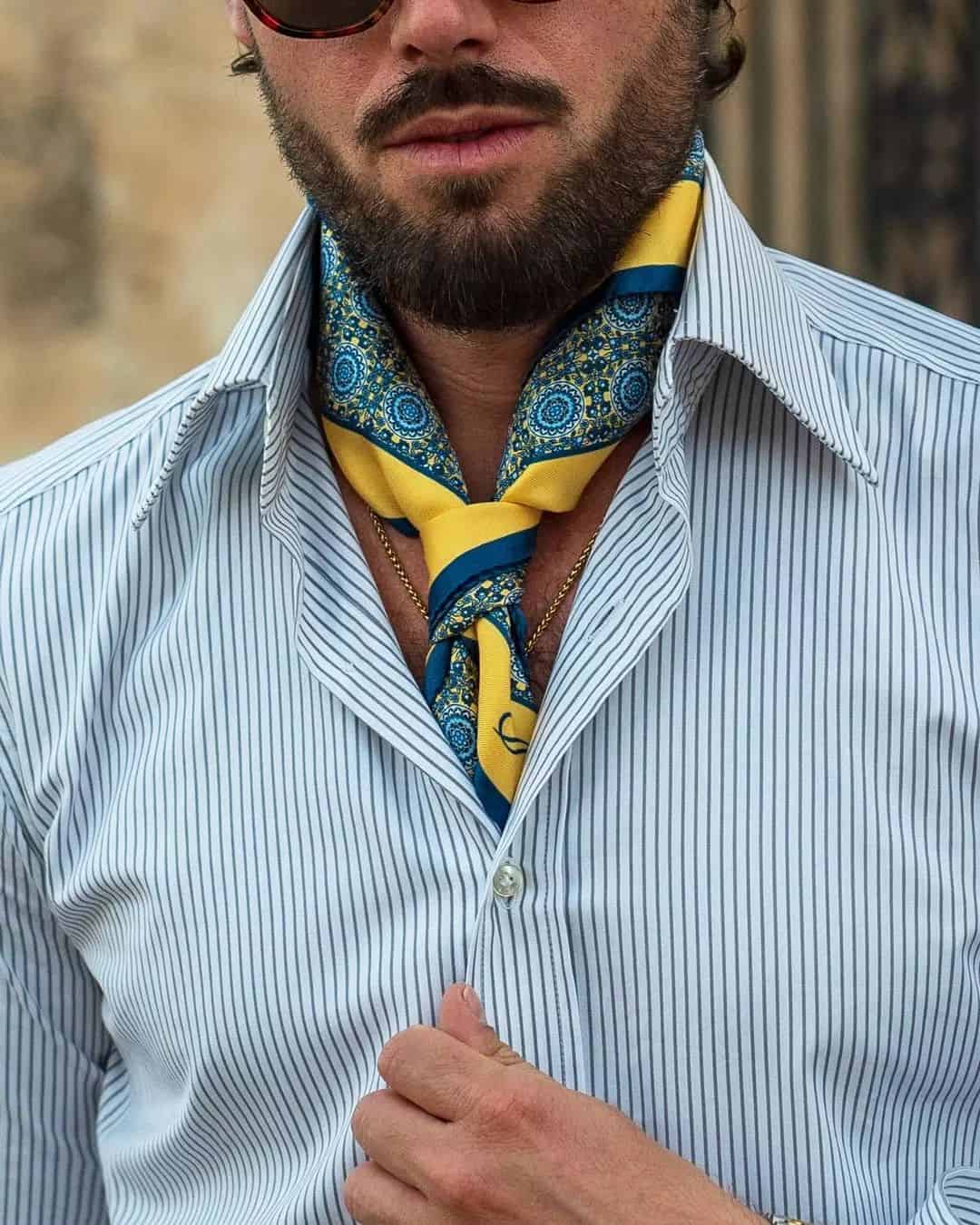 man wearing a blue and yellow scarf under a shirt