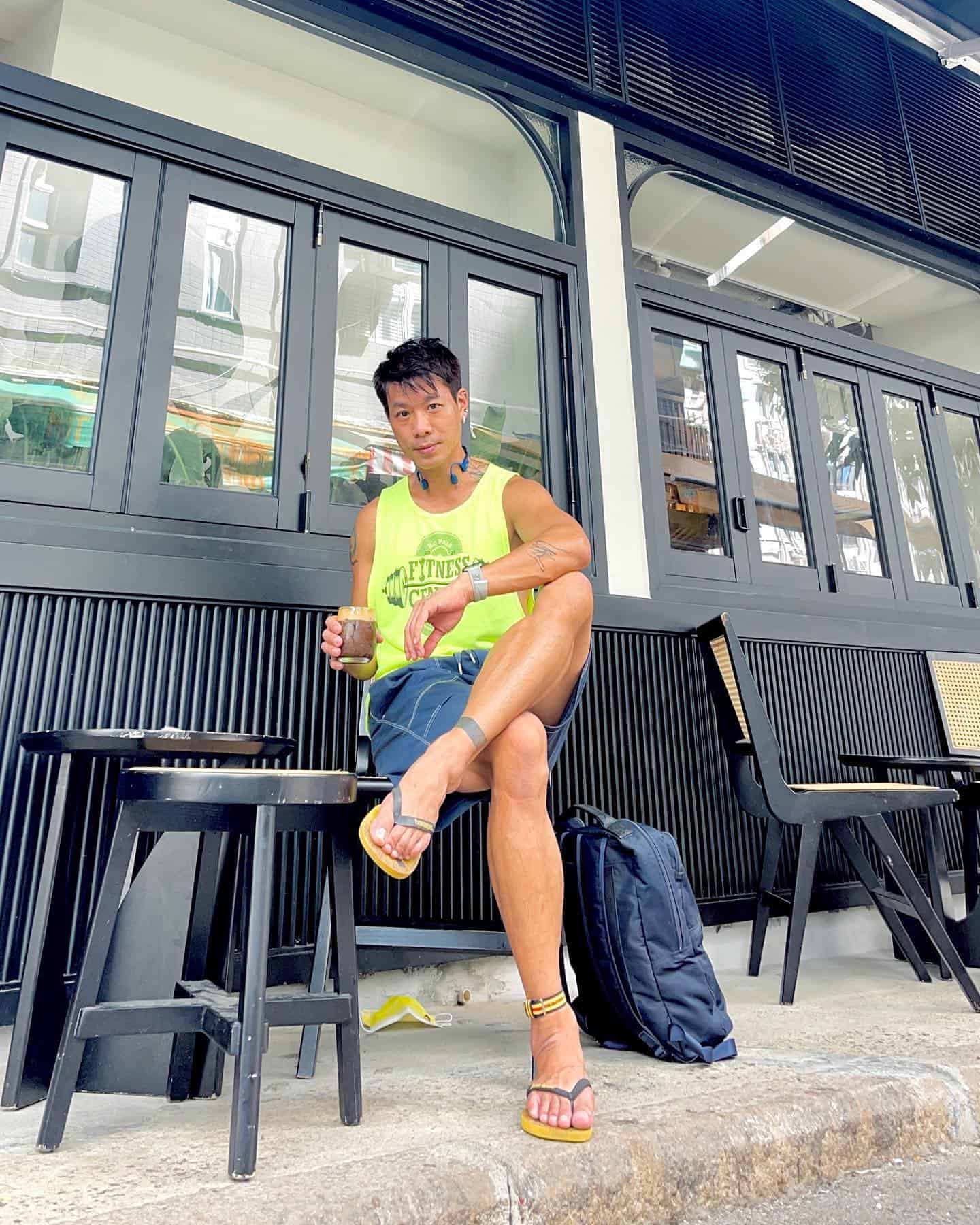 man sitting on a stool holding a glass of cold drink