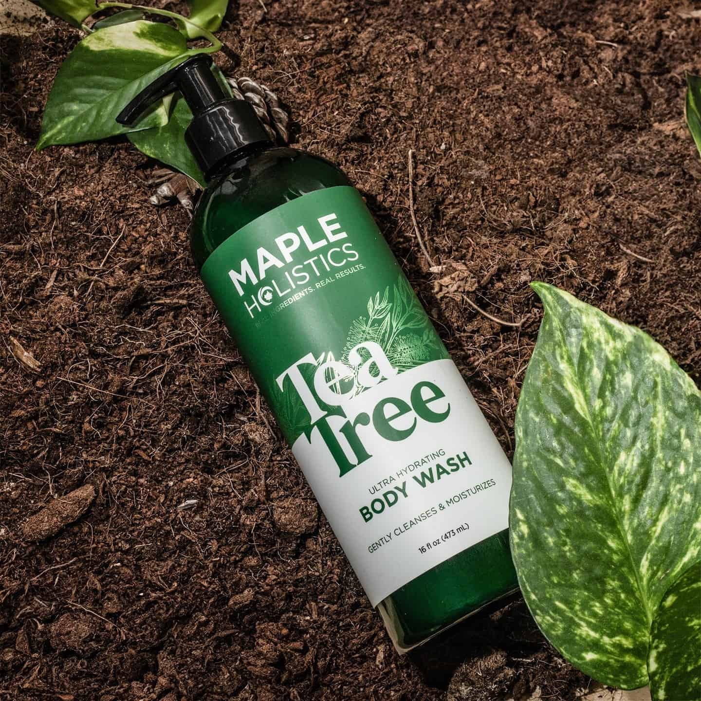 a bottle of maple holistics tea tree body wash on the ground