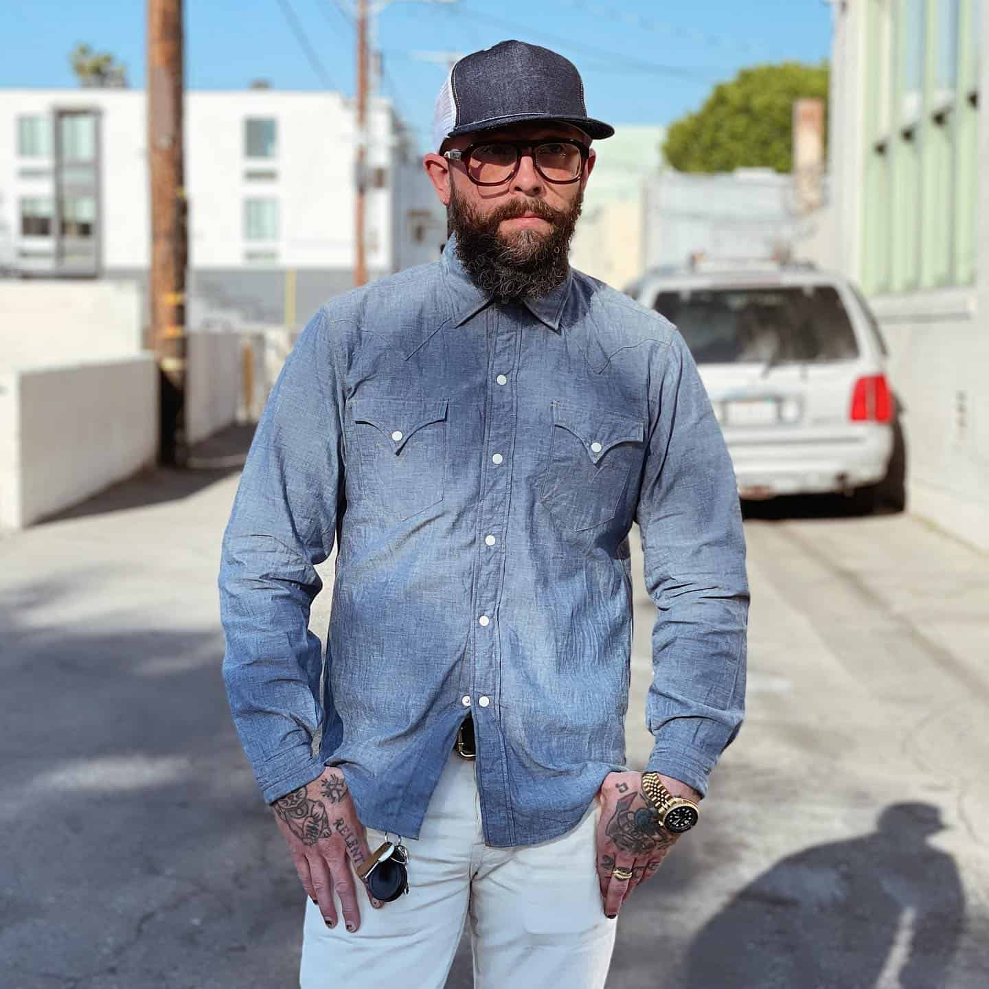 man in a denim trucker hat wearing a chambray shirt