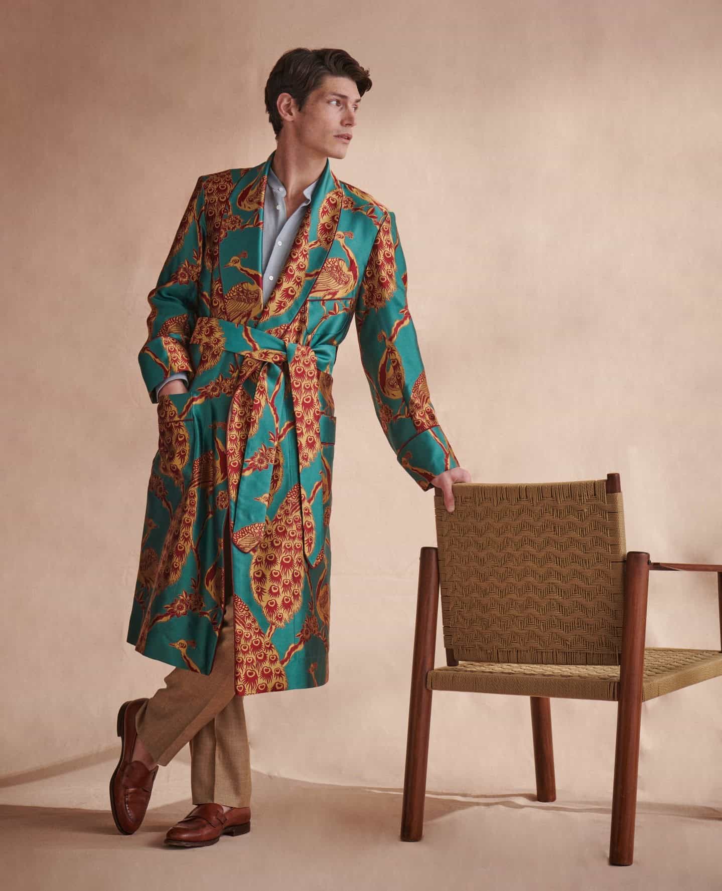 man wearing a peacock printed silk robe by new and lingwood