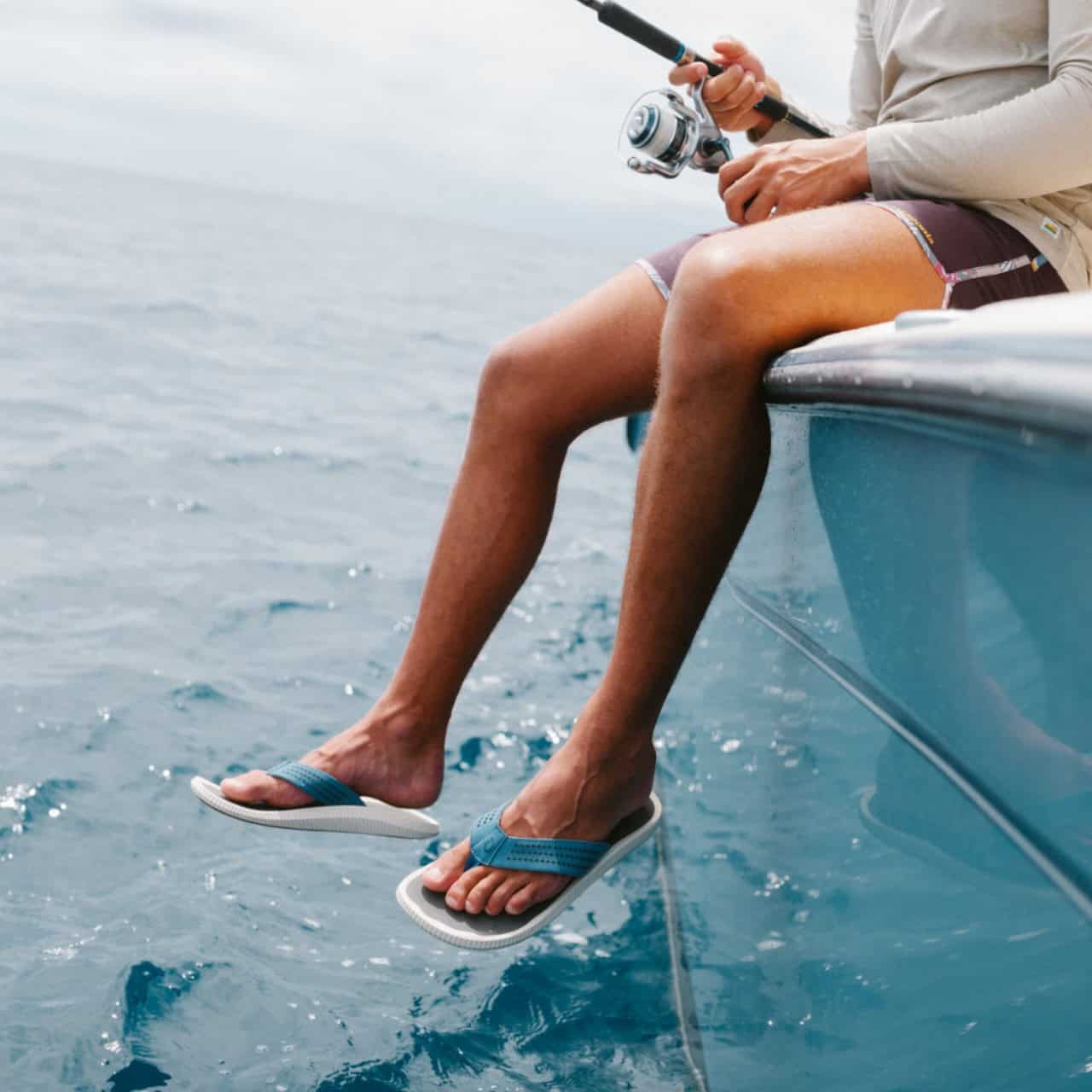 man fishing on a boat wearing flip flops