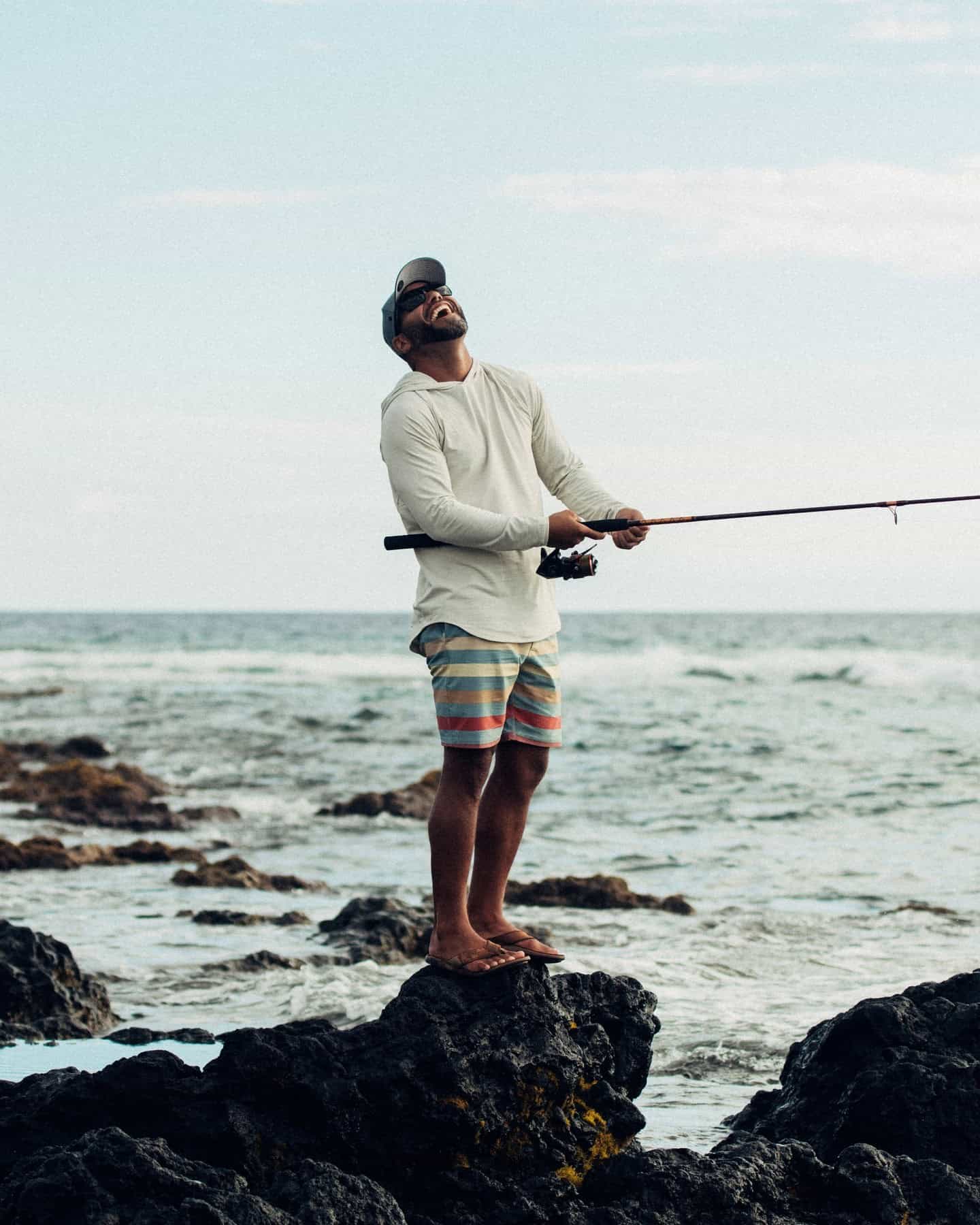 man holding a fishing rod laughing