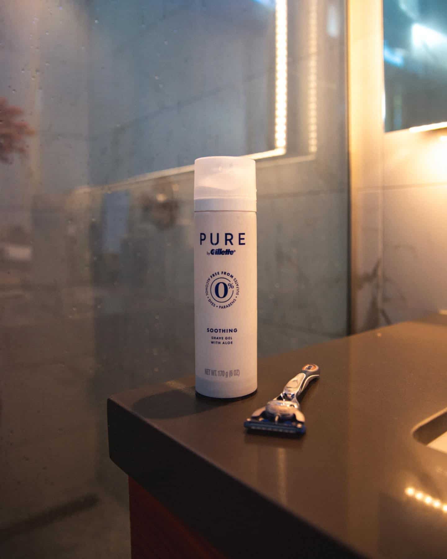 a bottle of gillette pure soothing shave gel and a safety razor on a sink