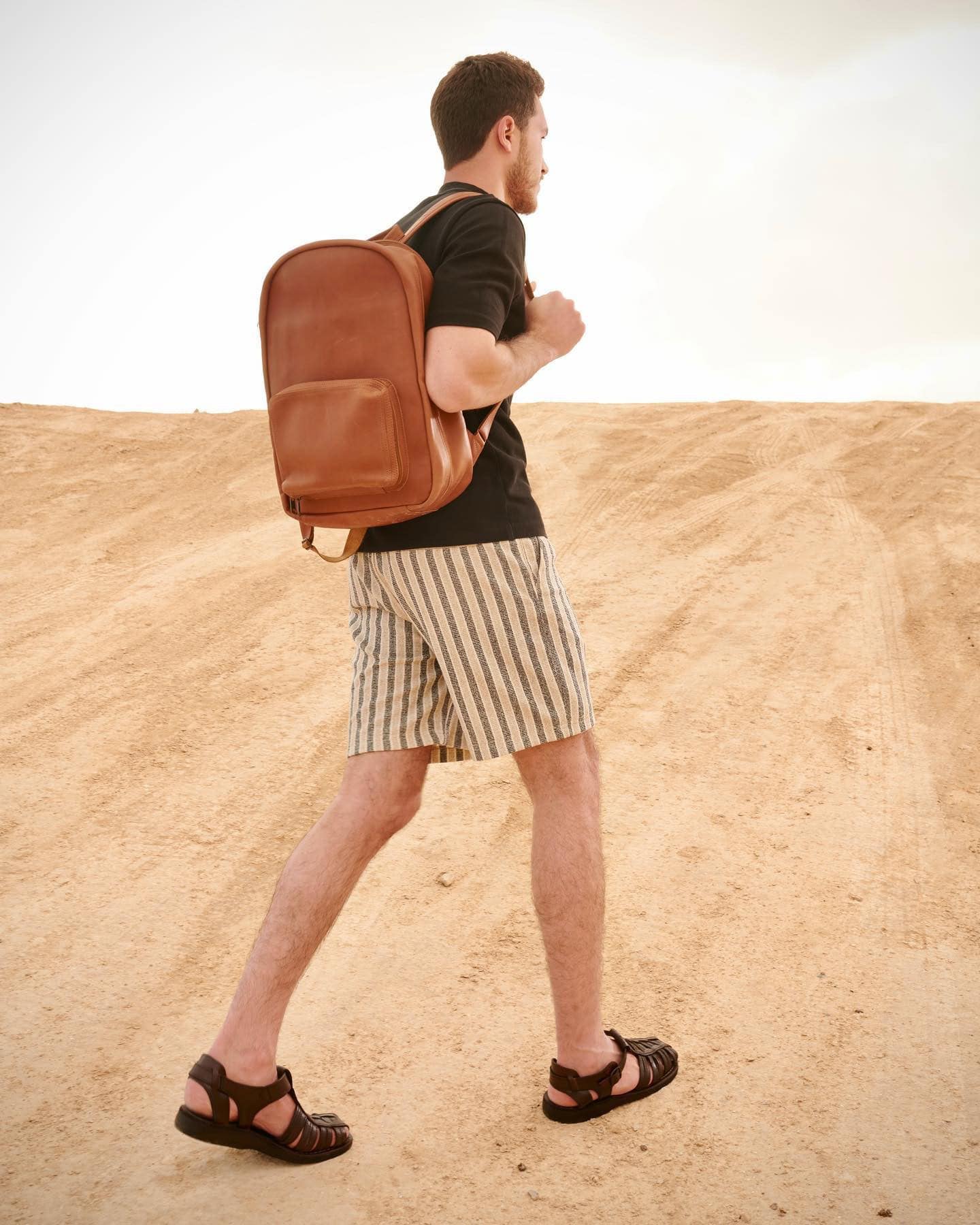 man walking the desert wearing a pair of closed toe sandals