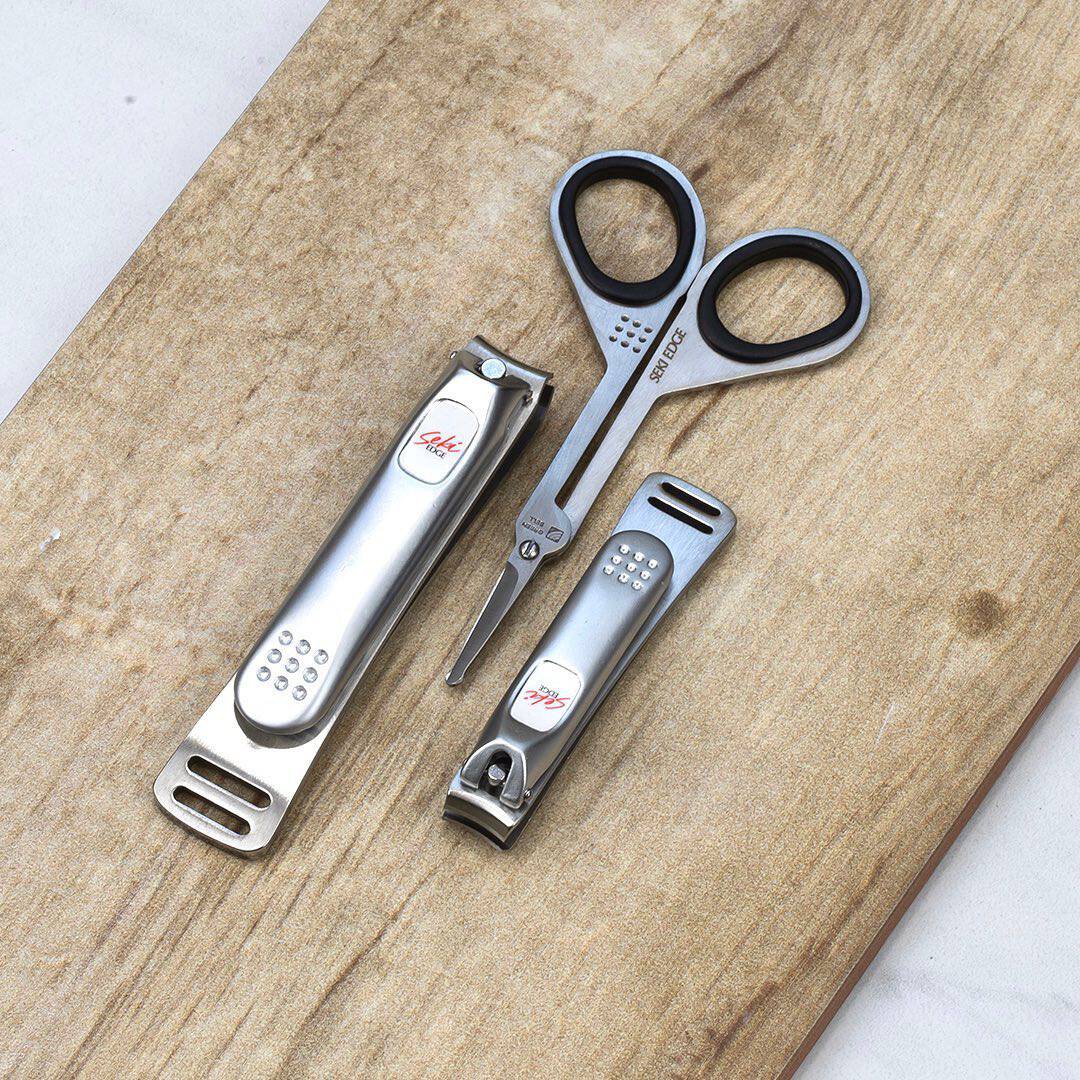 a round tip scissors in-between two nail cutters